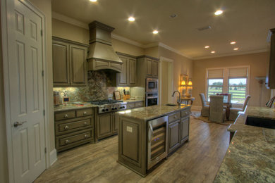 Inspiration for a mid-sized transitional u-shaped medium tone wood floor and brown floor kitchen remodel in Miami with an undermount sink, raised-panel cabinets, brown cabinets, laminate countertops, multicolored backsplash, stone slab backsplash, stainless steel appliances, an island and multicolored countertops