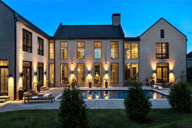 Huge transitional beige two-story brick exterior home idea in Little Rock with a shingle roof and a gray roof