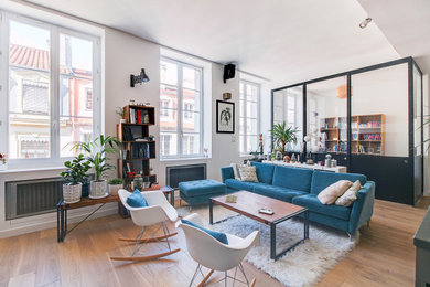 Idée de décoration pour un salon design ouvert avec un mur blanc, un sol en bois brun et un sol marron.