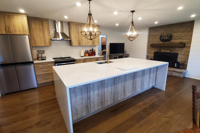 Huge elegant single-wall medium tone wood floor and brown floor eat-in kitchen photo in Toronto with an undermount sink, shaker cabinets, light wood cabinets, quartz countertops, white backsplash, quartz backsplash, stainless steel appliances, an island and white countertops