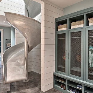 Design ideas for an expansive farmhouse galley utility room in Austin with blue cabinets, engineered stone countertops, blue walls, concrete flooring, a side by side washer and dryer and shaker cabinets.