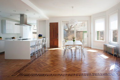 Trendy medium tone wood floor kitchen/dining room combo photo in New York with white walls