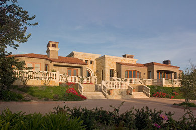 Example of a tuscan brown stucco house exterior design in San Diego with a tile roof