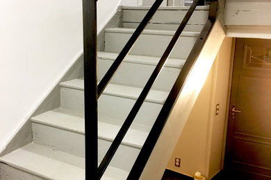 Ejemplo de escalera curva actual de tamaño medio con escalones de madera y barandilla de metal