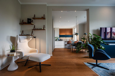 Großes, Repräsentatives, Offenes Modernes Wohnzimmer in grau-weiß mit beiger Wandfarbe, gebeiztem Holzboden, verstecktem TV und braunem Boden in Berlin