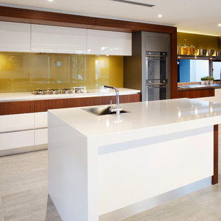 Contemporary kitchen pantry ideas - Example of a trendy galley ceramic floor kitchen pantry design in Perth with a drop-in sink, flat-panel cabinets, white cabinets, quartz countertops, green backsplash, glass sheet backsplash, stainless steel appliances and an island