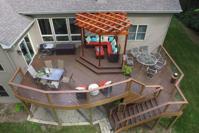 Ejemplo de terraza actual grande en patio trasero con cocina exterior, pérgola y barandilla de varios materiales