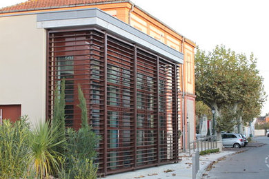 Idée de décoration pour une grande façade de maison design à un étage.