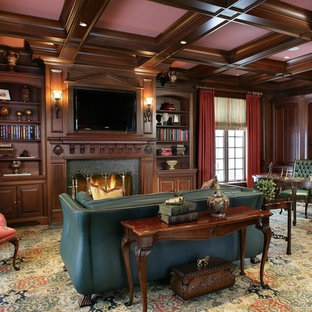 Imagen de despacho clásico, grande, con paredes marrones, moqueta, chimenea tradicional, marco de chimenea de piedra y escritorio independiente