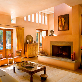 Imagen de salón abierto, mediterráneo, de tamaño medio, con parades naranjas, suelo de madera clara, chimenea tradicional, marco de chimenea de baldosas y/o azulejos y suelo negro