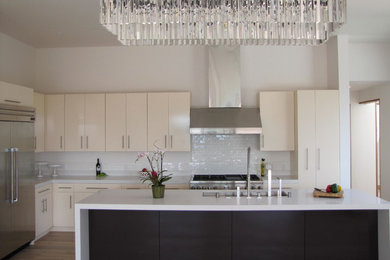 Open concept kitchen - mid-sized contemporary u-shaped light wood floor open concept kitchen idea in San Francisco with an undermount sink, flat-panel cabinets, quartz countertops, white backsplash, ceramic backsplash, stainless steel appliances and an island