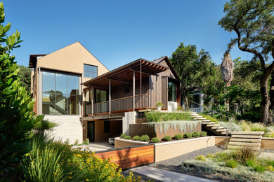 This is an example of a mid-sized modern drought-tolerant and full sun front yard concrete paver retaining wall landscape in Austin for summer.