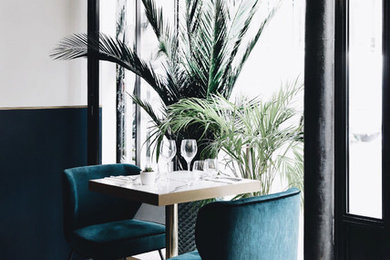 Aménagement d'une salle à manger ouverte sur le salon bord de mer de taille moyenne avec un mur bleu, sol en béton ciré, aucune cheminée et un sol blanc.
