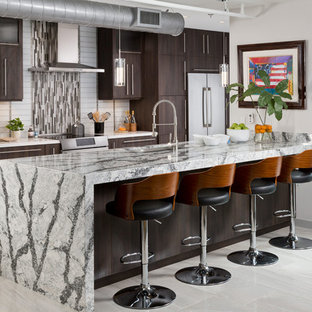 Foto de cocina industrial con fregadero bajoencimera, armarios con paneles lisos, puertas de armario de madera en tonos medios, encimera de granito, electrodomésticos de acero inoxidable, suelo de mármol, salpicadero multicolor, salpicadero con mosaicos de azulejos y península