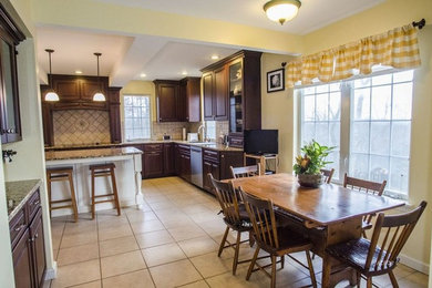 Eat-in kitchen - large traditional l-shaped ceramic tile and beige floor eat-in kitchen idea in Columbus with a double-bowl sink, beaded inset cabinets, dark wood cabinets, granite countertops, beige backsplash, ceramic backsplash, stainless steel appliances and an island