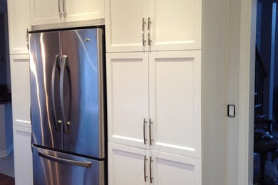 Eat-in kitchen - mid-sized contemporary l-shaped medium tone wood floor eat-in kitchen idea in Montreal with an undermount sink, shaker cabinets, white cabinets, quartzite countertops, white backsplash, ceramic backsplash, stainless steel appliances and an island