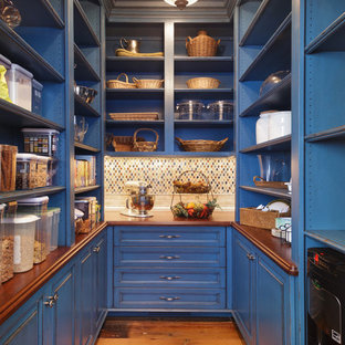 Idée de décoration pour une arrière-cuisine tradition en U avec un placard sans porte, des portes de placard bleues, un plan de travail en bois, une crédence multicolore, une crédence en mosaïque et un sol en bois brun.