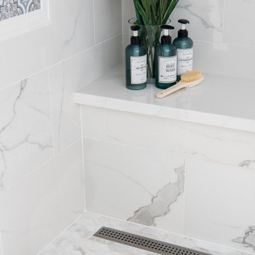 Linear drain set into elongated hexagon mosaic porcelain shower floor tiles