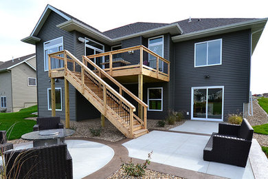 Large traditional gray two-story vinyl house exterior idea in Cedar Rapids with a hip roof and a shingle roof