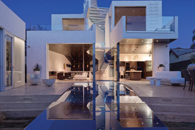 This is an example of a mid-sized contemporary two-storey stucco white exterior in Los Angeles with a flat roof.