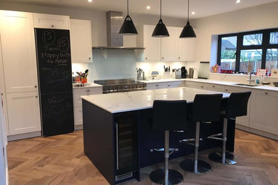 Moderne Küche mit Schrankfronten im Shaker-Stil, blauen Schränken und Kücheninsel in Hertfordshire