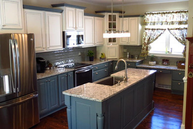 Kitchen - large country medium tone wood floor and brown floor kitchen idea in DC Metro with a farmhouse sink, raised-panel cabinets, beige cabinets, granite countertops, blue backsplash, subway tile backsplash, stainless steel appliances and an island