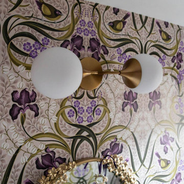 Brass Globe Sconce Against Botanical Statement Wallpaper