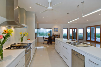 Inspiration for a modern galley eat-in kitchen in Cairns with a double-bowl sink, white cabinets, granite benchtops, white splashback and beige floor.