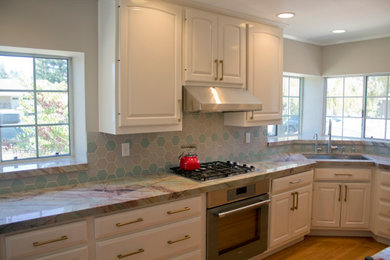 Inspiration for a large transitional l-shaped light wood floor eat-in kitchen remodel in San Francisco with an undermount sink, white cabinets, quartzite countertops, multicolored backsplash, ceramic backsplash, stainless steel appliances, no island and multicolored countertops