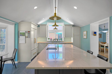 Example of a large eclectic u-shaped gray floor, vaulted ceiling and porcelain tile open concept kitchen design in Chicago with an undermount sink, shaker cabinets, white cabinets, green backsplash, an island, white countertops, quartzite countertops and porcelain backsplash