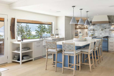 Country l-shaped light wood floor and brown floor open concept kitchen photo in Vancouver with quartz countertops, multicolored backsplash, glass tile backsplash, an island, white countertops, a farmhouse sink, shaker cabinets, white cabinets and colored appliances