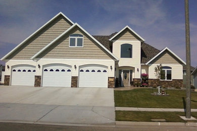 Large elegant beige two-story mixed siding house exterior photo in Other with a hip roof and a shingle roof