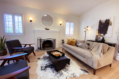 Example of a mid-sized trendy open concept light wood floor living room design in Los Angeles with white walls and a standard fireplace