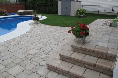Example of a large backyard concrete paver patio fountain design in Ottawa