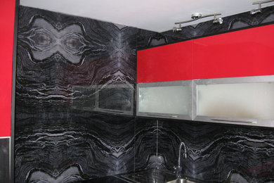 Diseño de cocina escandinava de tamaño medio sin isla con fregadero encastrado, armarios tipo vitrina, puertas de armario rojas, encimera de cuarzo compacto, salpicadero negro, salpicadero de vidrio templado, electrodomésticos de acero inoxidable, suelo de mármol y suelo beige