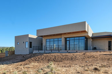 Inspiration for a mid-sized contemporary beige one-story stucco exterior home remodel in Albuquerque
