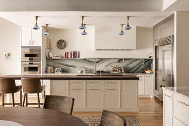 Inspiration for a contemporary l-shaped medium tone wood floor and brown floor eat-in kitchen remodel in Philadelphia with an undermount sink, shaker cabinets, white cabinets, gray backsplash, stone slab backsplash, stainless steel appliances, an island and brown countertops