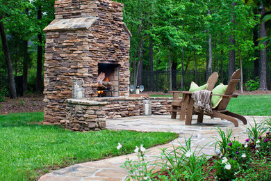 Patio - large traditional backyard stone patio idea in Charlotte with a fire pit and no cover