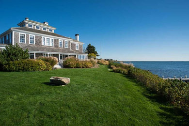 This is an example of a large traditional full sun front yard stone landscaping in Boston for spring.