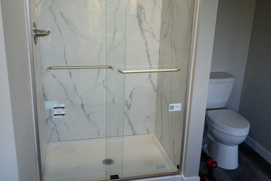 シアトルにある小さなトランジショナルスタイルのおしゃれな浴室 (置き型浴槽、アルコーブ型シャワー、一体型トイレ	、グレーの壁、クッションフロア、グレーの床) の写真