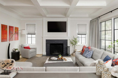 Example of a large enclosed light wood floor, beige floor and coffered ceiling living room design with white walls, a standard fireplace and a wall-mounted tv