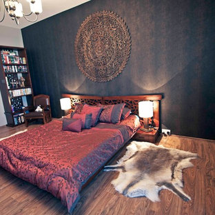 Foto di una camera da letto etnica con pareti marroni e pavimento in laminato