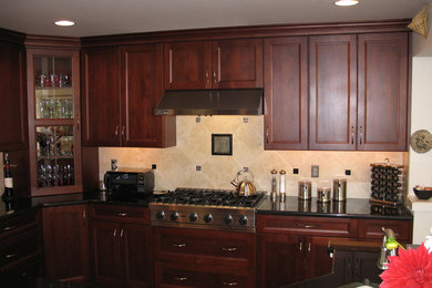 Inspiration for a mid-sized timeless l-shaped medium tone wood floor open concept kitchen remodel in Seattle with an undermount sink, shaker cabinets, dark wood cabinets, solid surface countertops, beige backsplash, ceramic backsplash, stainless steel appliances and an island
