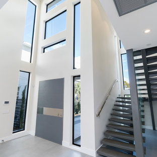 This is an example of a large contemporary curved metal railing staircase in Los Angeles with slate treads and slate risers.