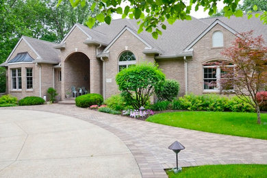 Inspiration for a large timeless brown one-story brick gable roof remodel in Indianapolis