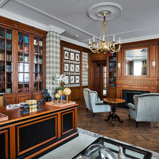 Photo of a traditional study room in Moscow with multi-coloured walls, dark hardwood floors, a standard fireplace, a freestanding desk and a wood fireplace surround.
