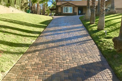 This is an example of a large traditional partial sun front yard brick landscaping in Orange County.