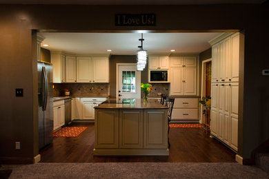 Open concept kitchen - mid-sized traditional galley dark wood floor open concept kitchen idea in Chicago with an undermount sink, raised-panel cabinets, white cabinets, quartzite countertops, beige backsplash, porcelain backsplash, stainless steel appliances and an island