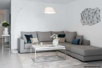 Imagen de sala de estar tipo loft minimalista con paredes blancas, suelo de baldosas de cerámica, televisor colgado en la pared y suelo gris