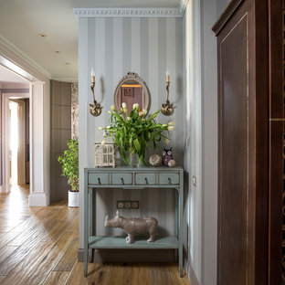 Bild på en vintage hall, med grå väggar och mellanmörkt trägolv